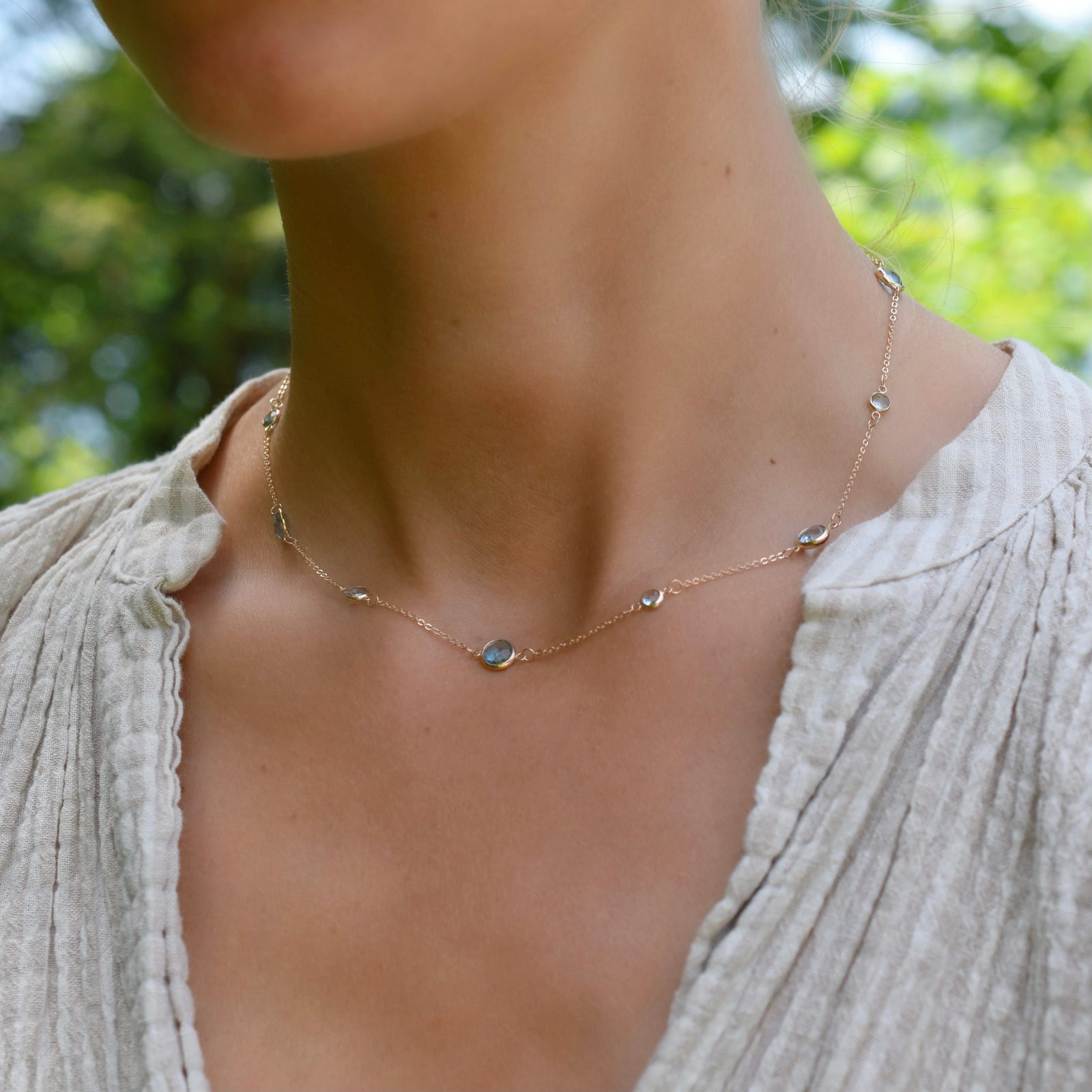 Woman wearing a Bayberry Grand & Classic 14k gold necklace featuring alternating 4 mm & 6 mm briolette Nantucket blue topaz