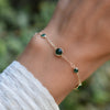 Woman wearing a Bayberry Grand & Classic cable chain bracelet in 14k gold featuring seven alternating 4 mm and 6 mm emeralds