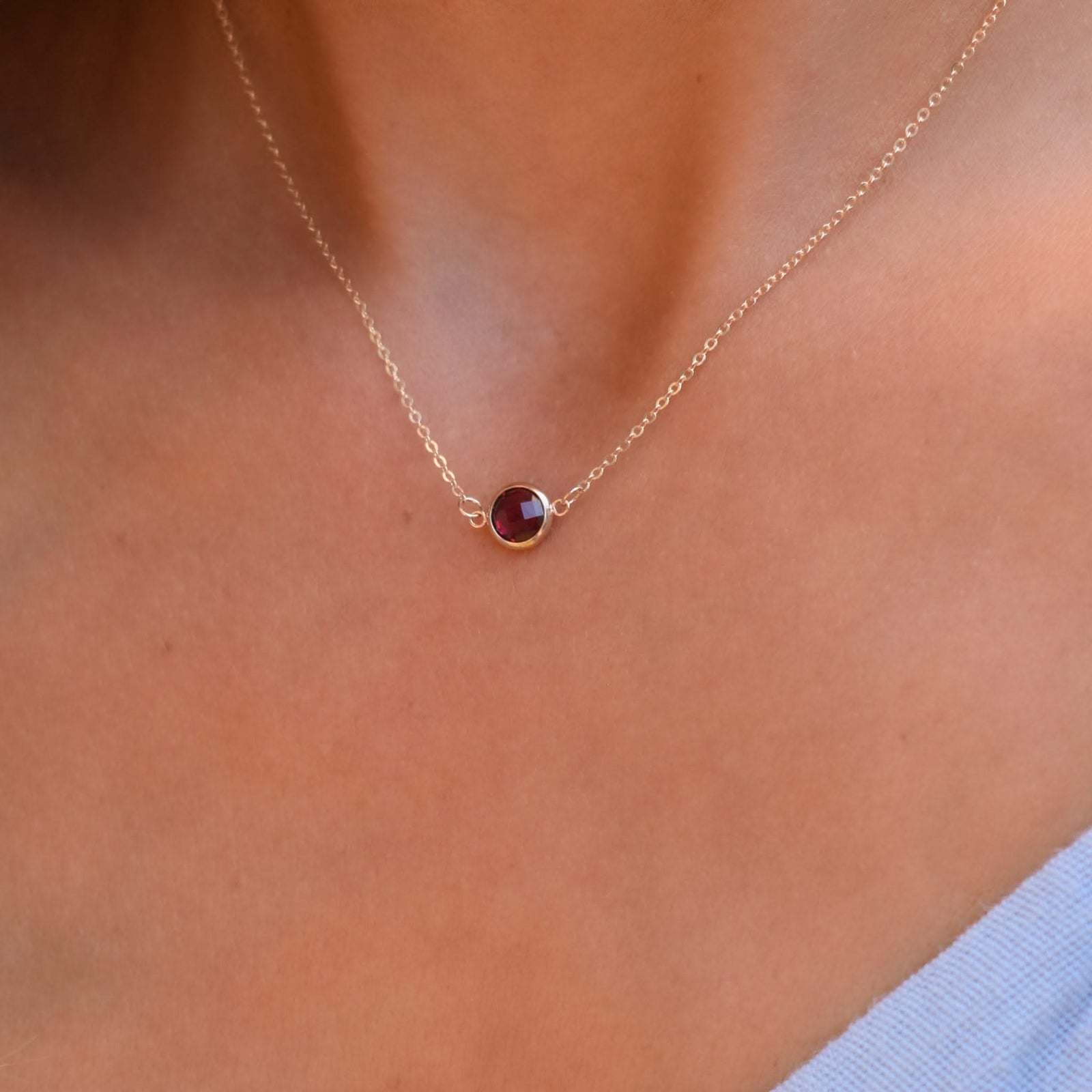 Woman with a Grand 14k yellow gold 1.17 mm cable chain necklace featuring one 6 mm briolette cut bezel set ruby