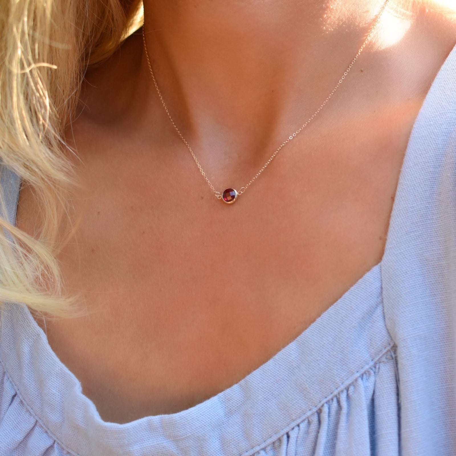 Woman wearing a Grand 14k yellow gold 1.17 mm cable chain necklace featuring one 6 mm briolette cut bezel set ruby