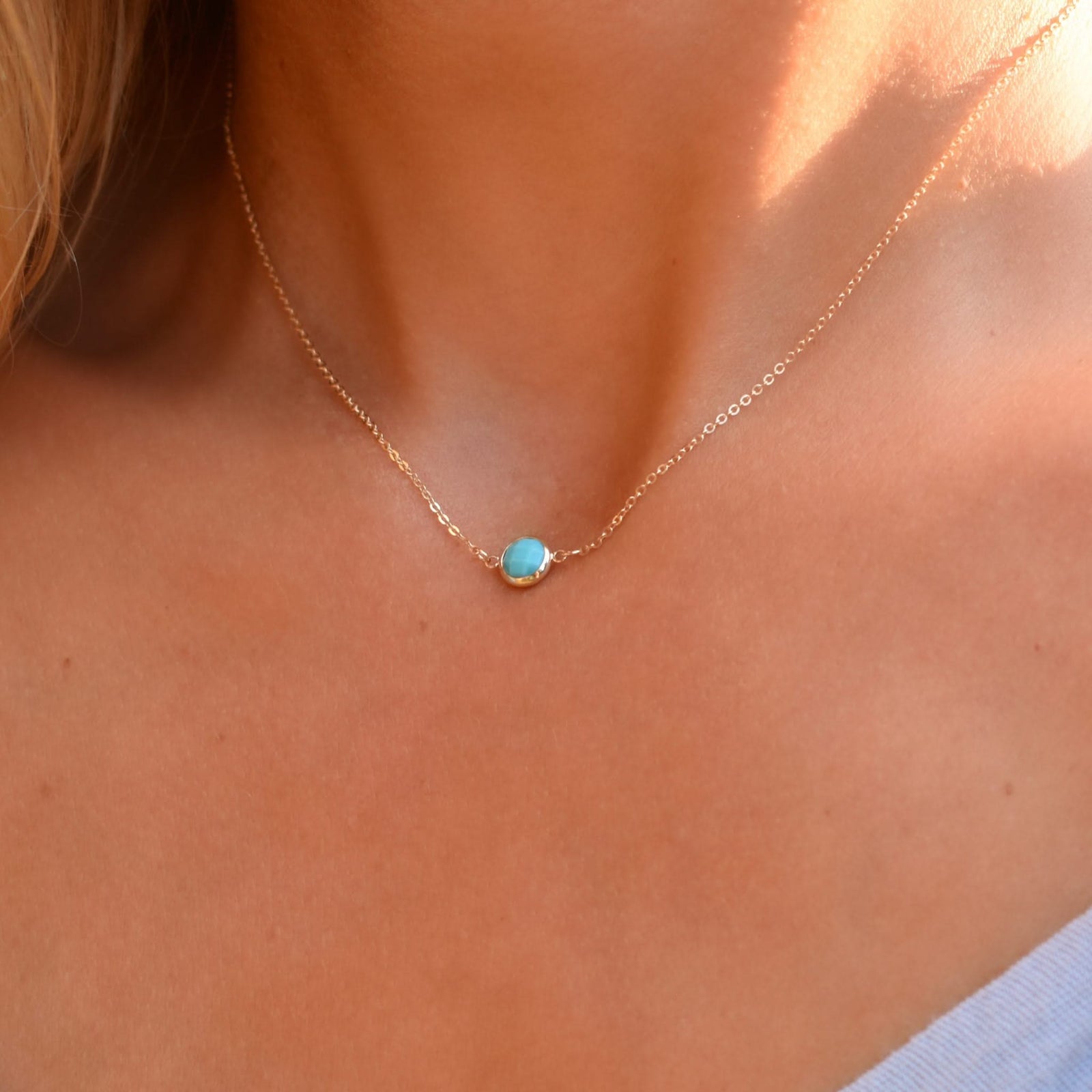 Woman with a Grand 14k yellow gold 1.17 mm cable chain necklace featuring one 6 mm briolette cut bezel set turquoise