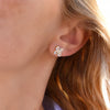 Woman wearing a 14k yellow gold Greenwich 4 Birthstone earring featuring four 4 mm white topaz and one 2.1 mm diamond