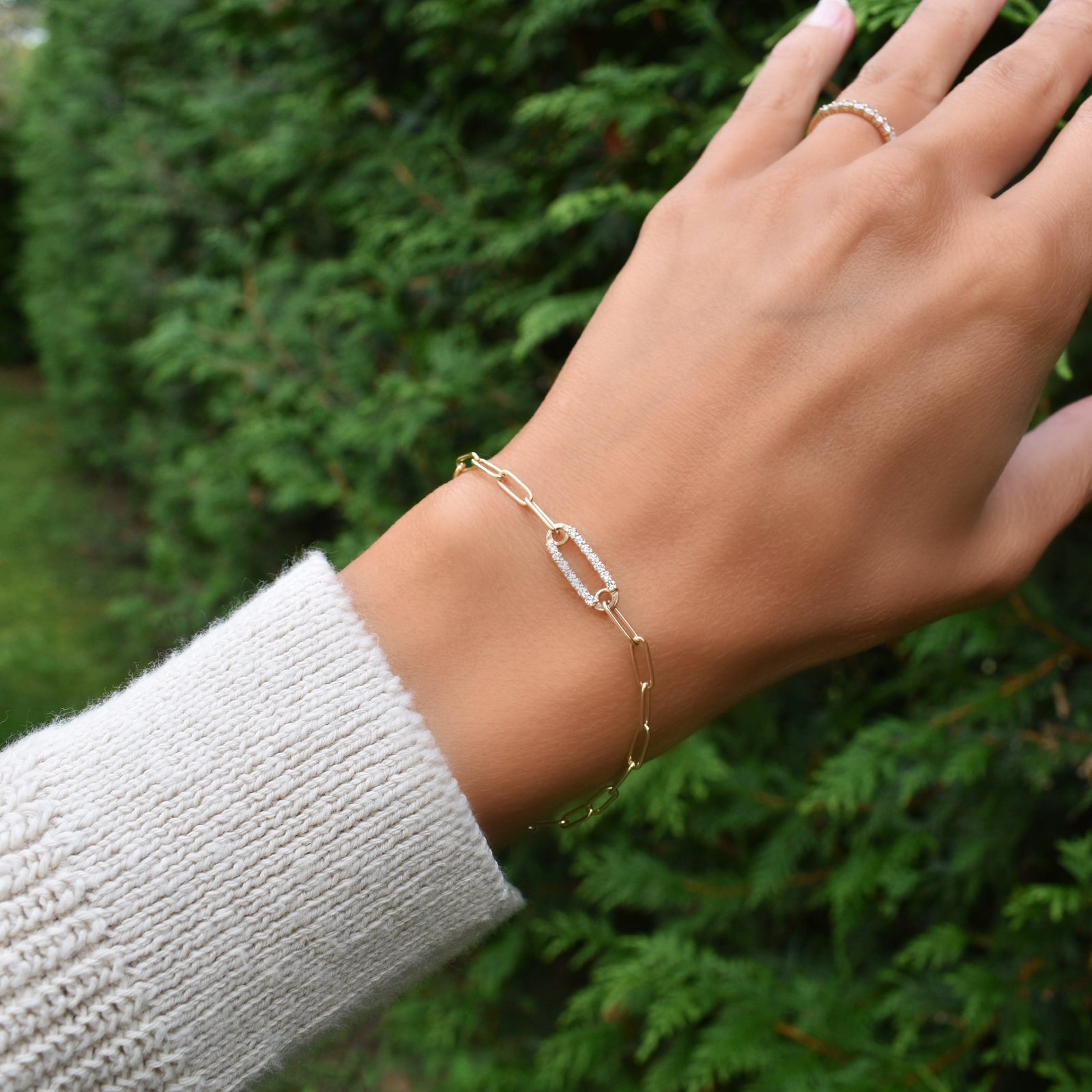 Woman wearing a 14k yellow gold Adelaide paperclip chain pavé bracelet featuring one diamond-encrusted link