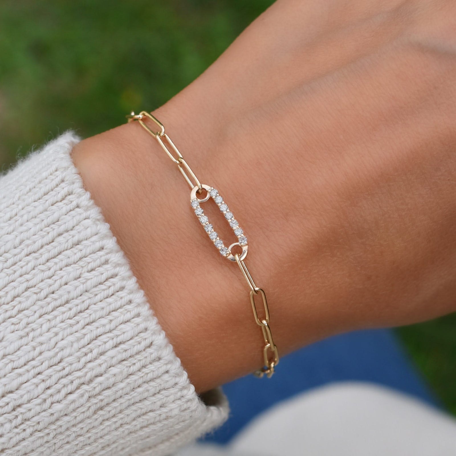 Woman wearing a 14k yellow gold Adelaide paperclip chain pavé bracelet featuring one white topaz-encrusted link