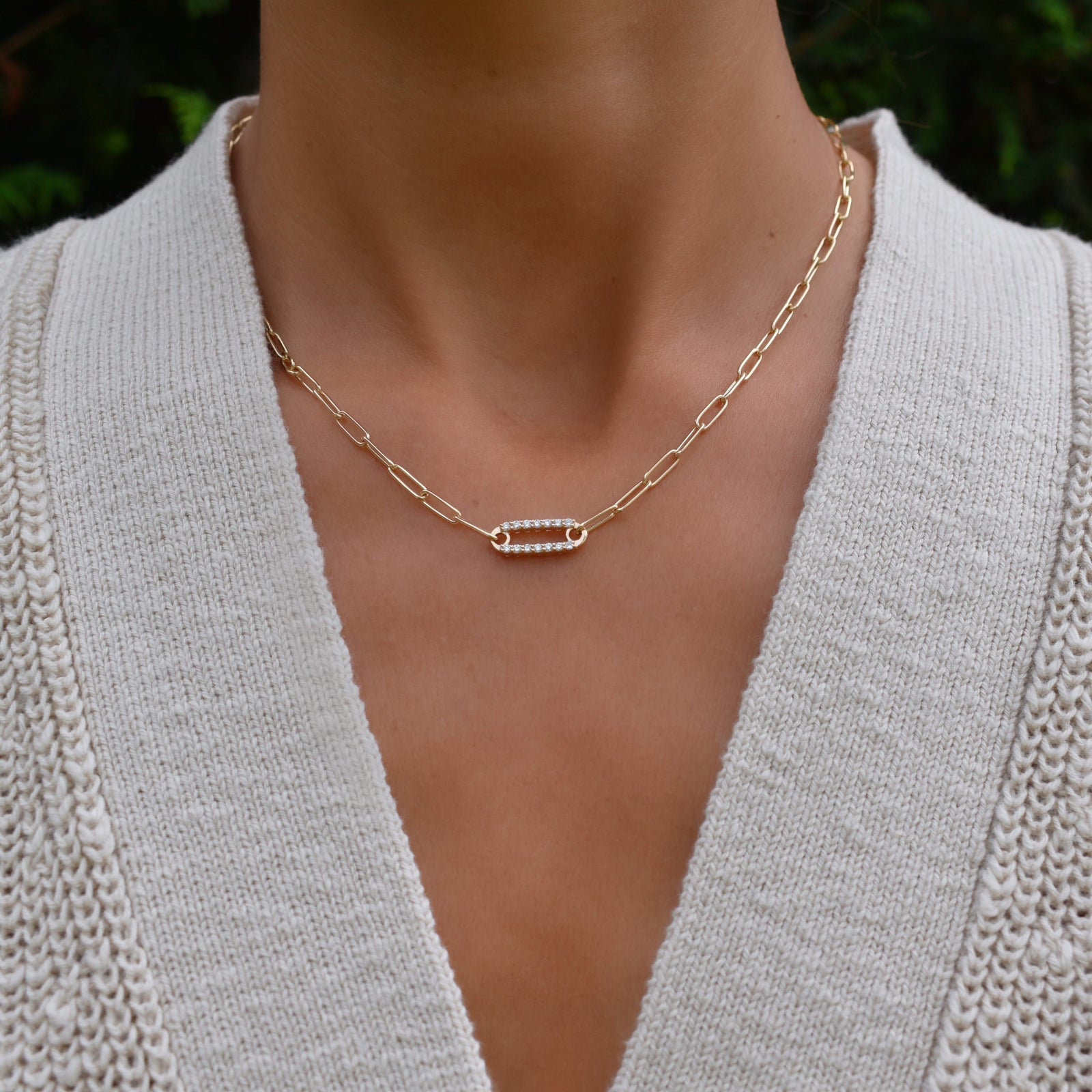 Woman with a 14k yellow gold Adelaide paperclip chain necklace featuring one link encrusted with 1.5 mm pavé diamonds