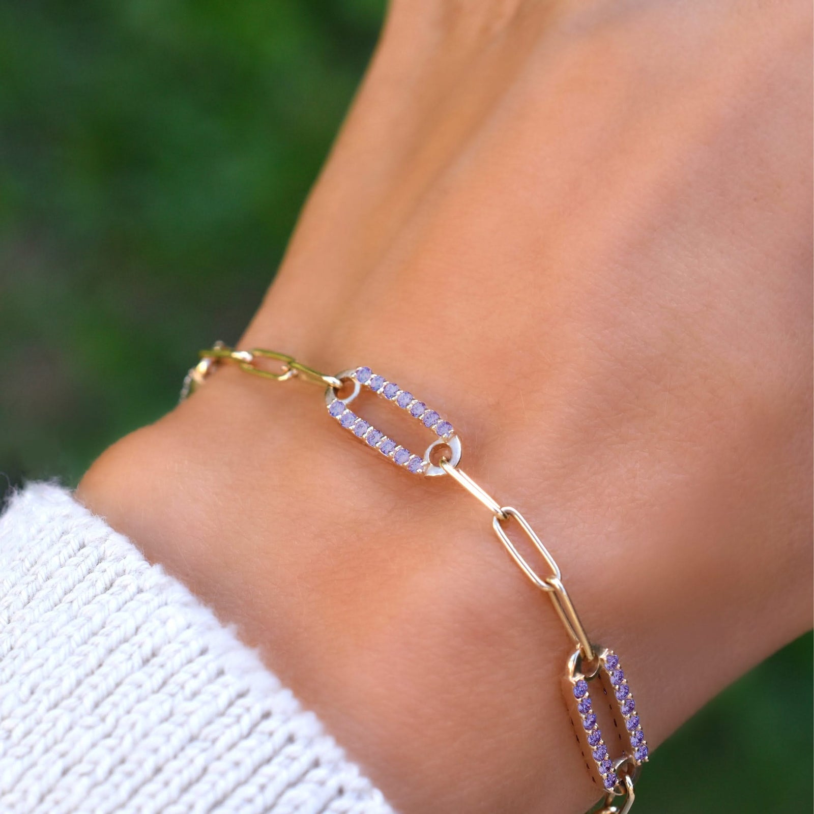 Woman wearing a 14k yellow gold Adelaide paperclip chain pavé bracelet featuring amethyst-encrusted links