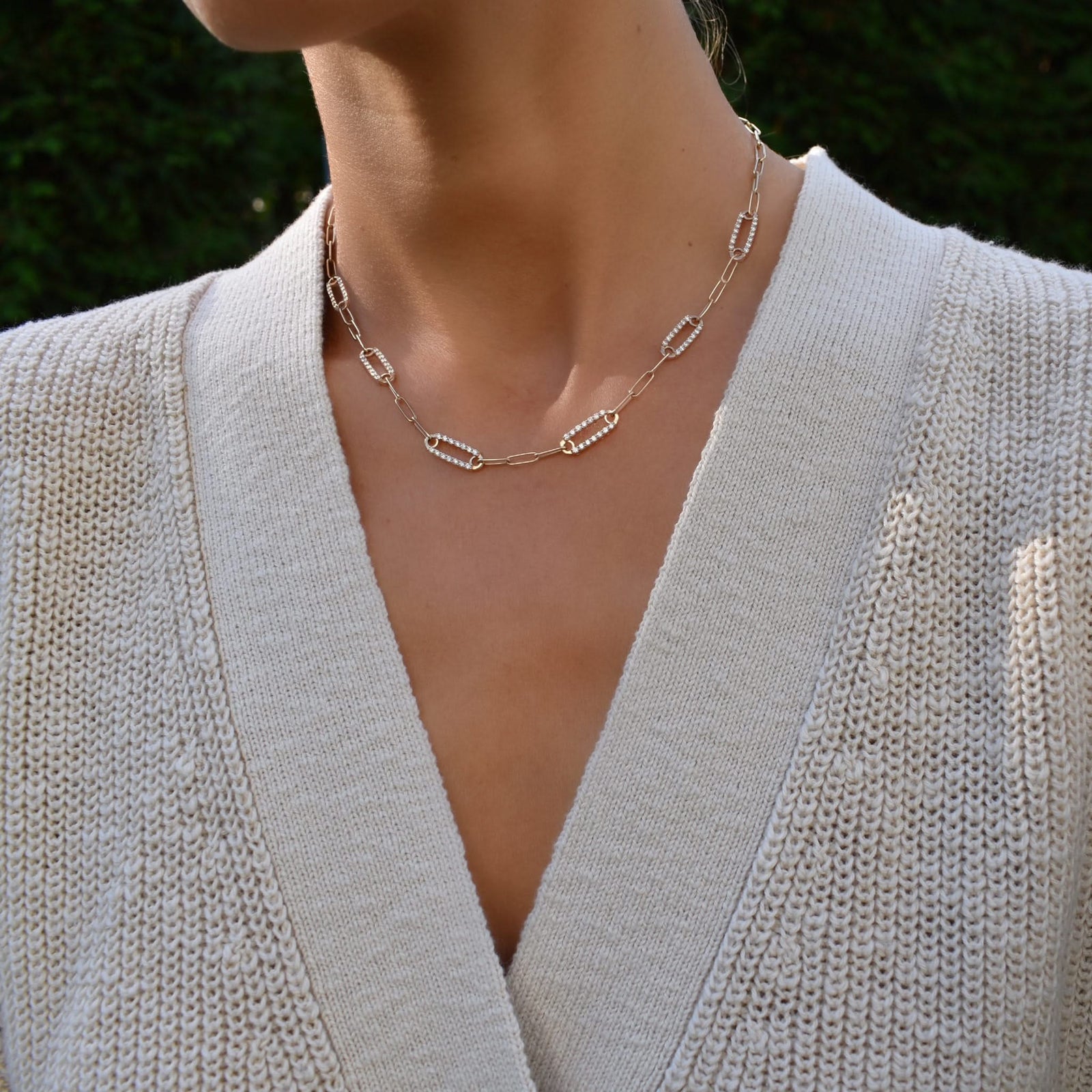 Woman wearing a 14k gold Adelaide paperclip chain pavé necklace featuring six gemstone-encrusted links