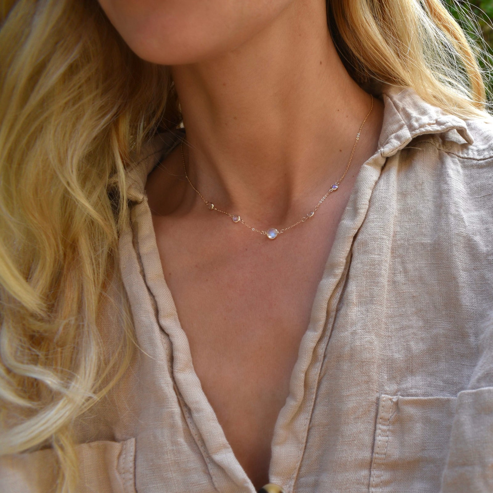 Woman with a Grand & Classic necklace featuring one 6 mm and four 4 mm Moonstones bezel set in 14k yellow gold