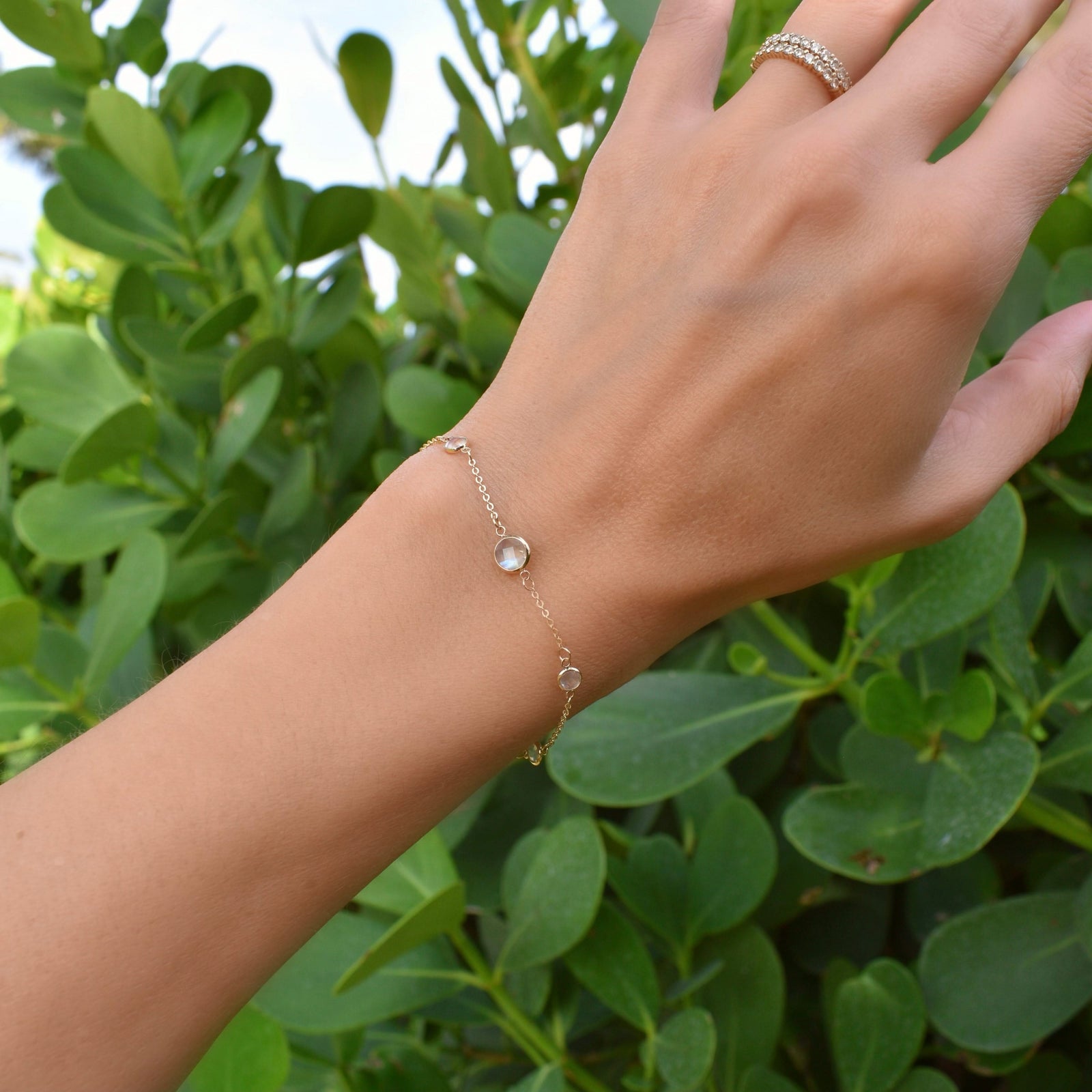 Woman wearing a Grand & Classic bracelet featuring one 6 mm and four 4 mm briolette Moonstones bezel set in 14k yellow gold