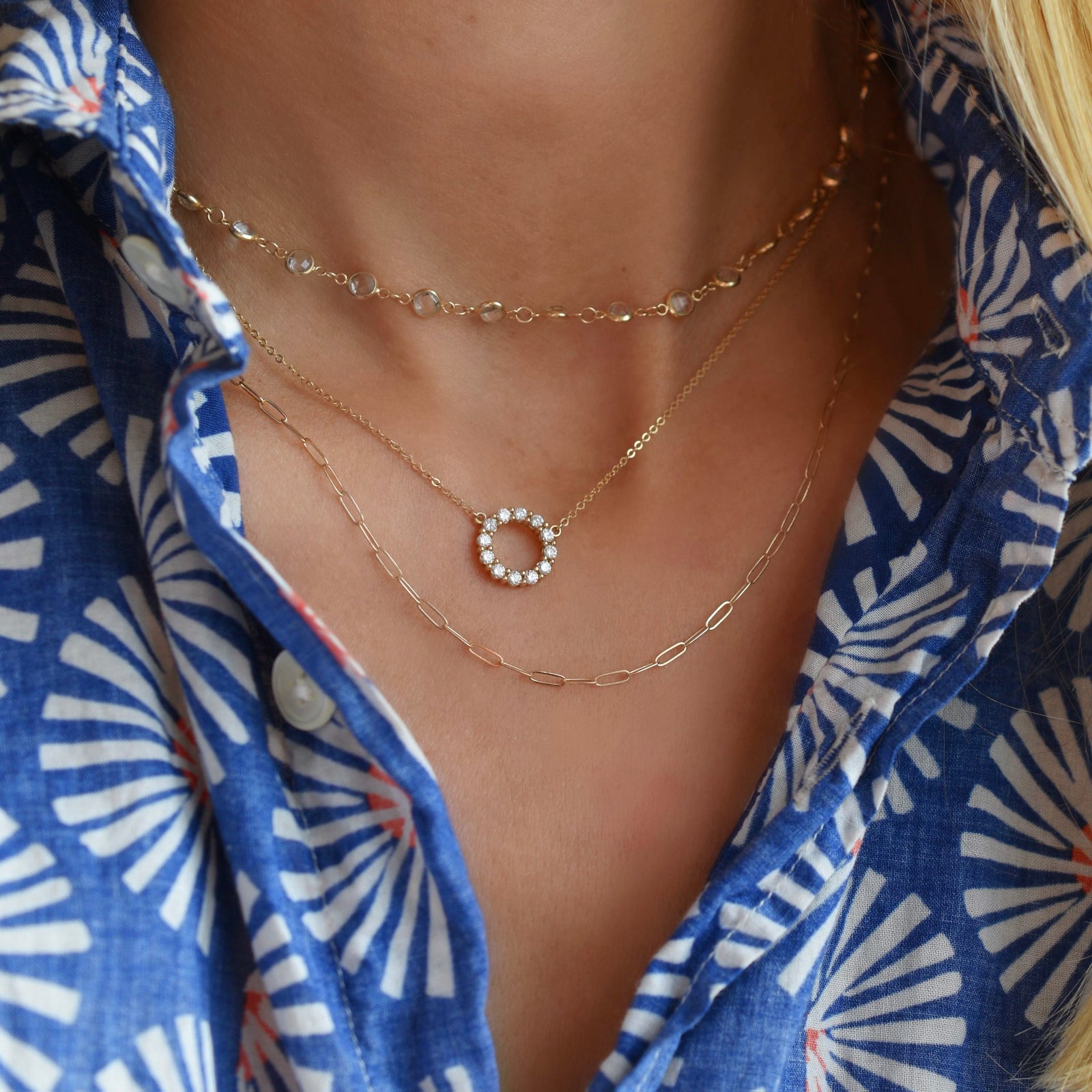 Woman with layered gold necklaces including a Rosecliff small open circle necklace featuring twelve 2 mm faceted white topaz