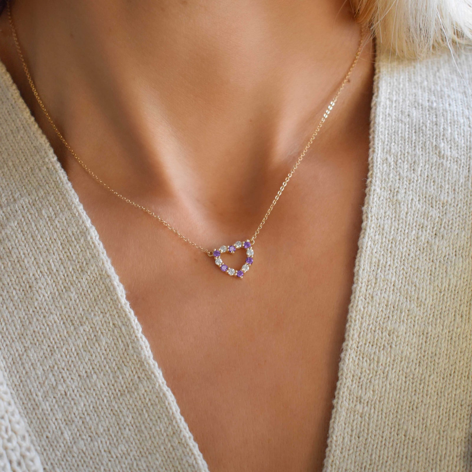 Woman wearing a Rosecliff Heart Necklace featuring twelve alternating amethysts and diamonds prong set in 14k yellow Gold