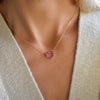 Woman wearing a Rosecliff Heart Necklace featuring twelve faceted round cut rubies prong set in 14k yellow Gold