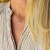 Woman wearing a Rosecliff small open circle necklace with 12 alternating 2 mm alexandrites & diamonds prong set in 14k gold