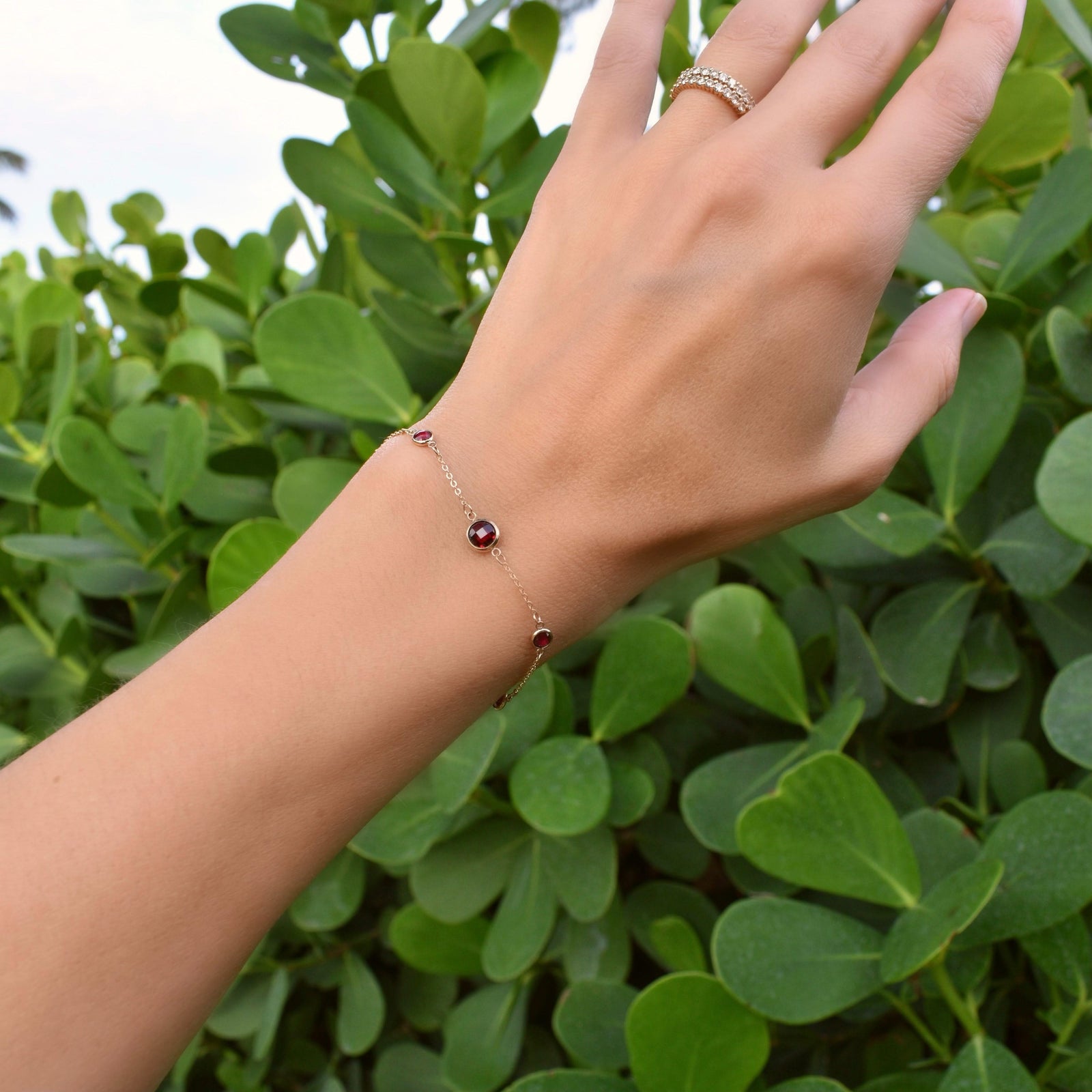 Woman with a Grand & Classic bracelet featuring one 6 mm and four 4 mm briolette Rubies bezel set in 14k yellow gold