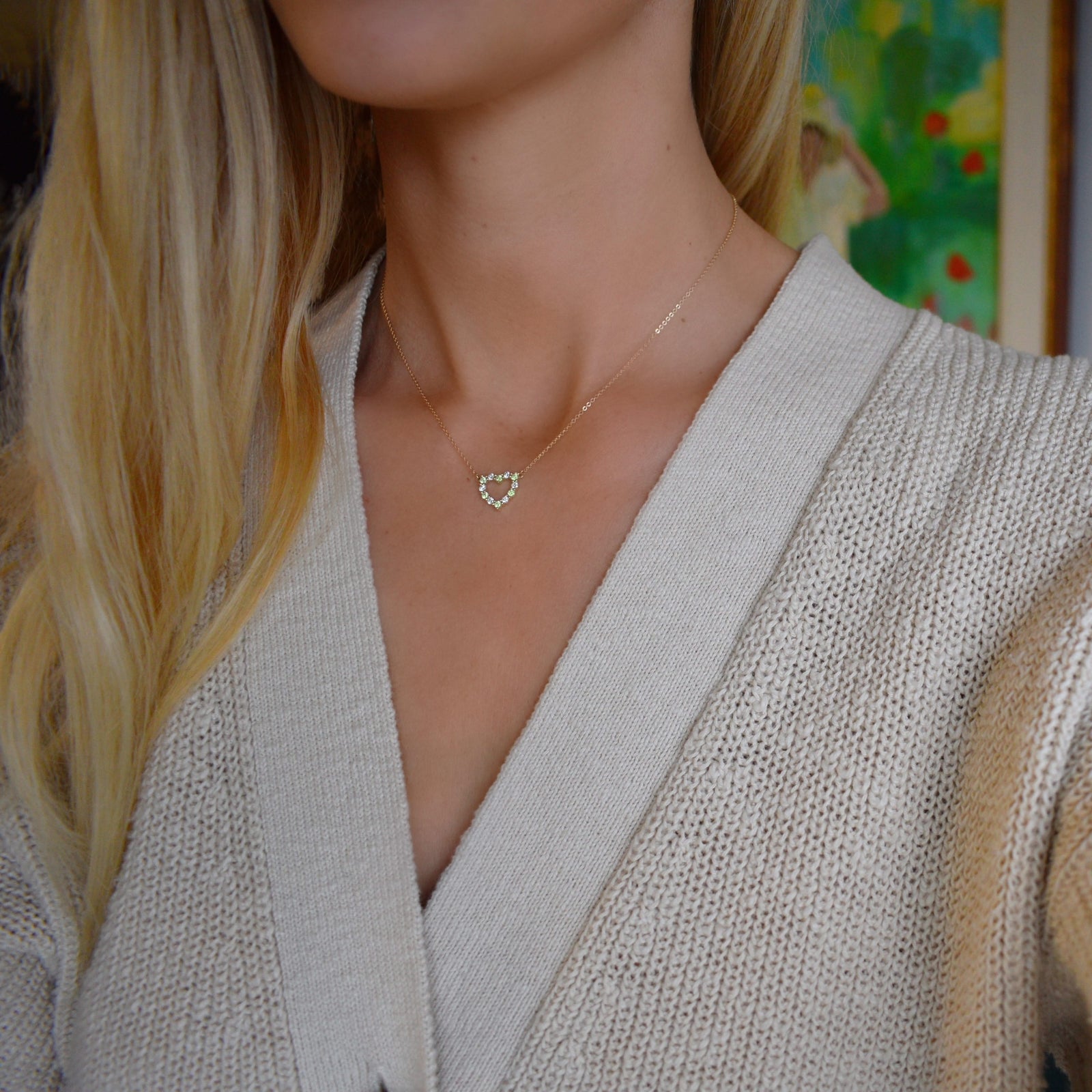 Woman with a Rosecliff Heart Necklace featuring twelve alternating peridots and diamonds prong set in 14k yellow Gold