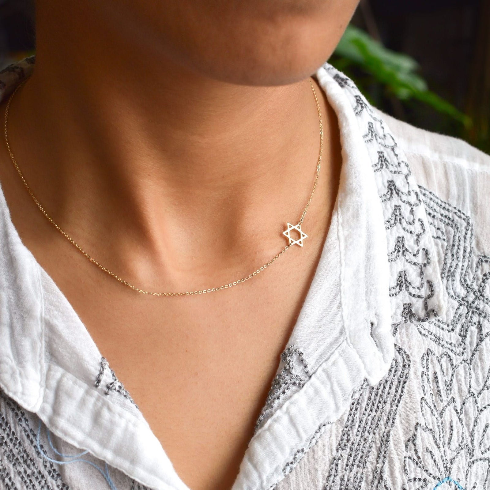 Woman with a 14k yellow gold Classic necklace featuring a 1/2" cutout Star of David