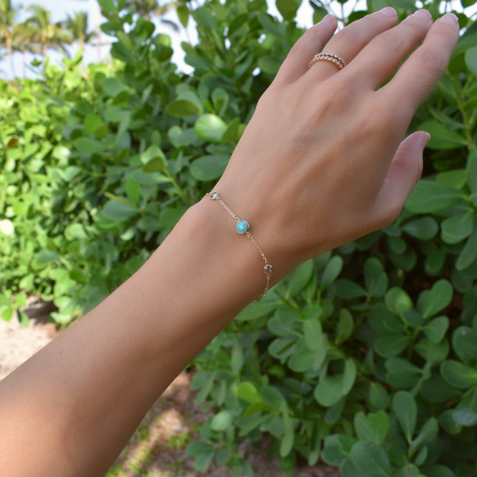 Woman wearing a Grand & Classic bracelet featuring one 6 mm Turquoise & four 4 mm Nantucket Blue Topaz bezel set in 14k gold