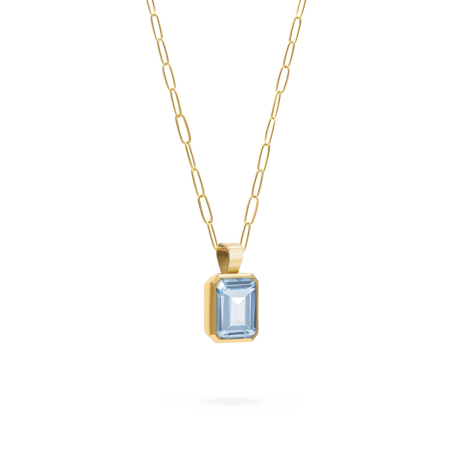 Adelaide paper clip chain and a Warren pendant with an emerald cut bezel set aquamarine gemstone in 14k gold - angled view