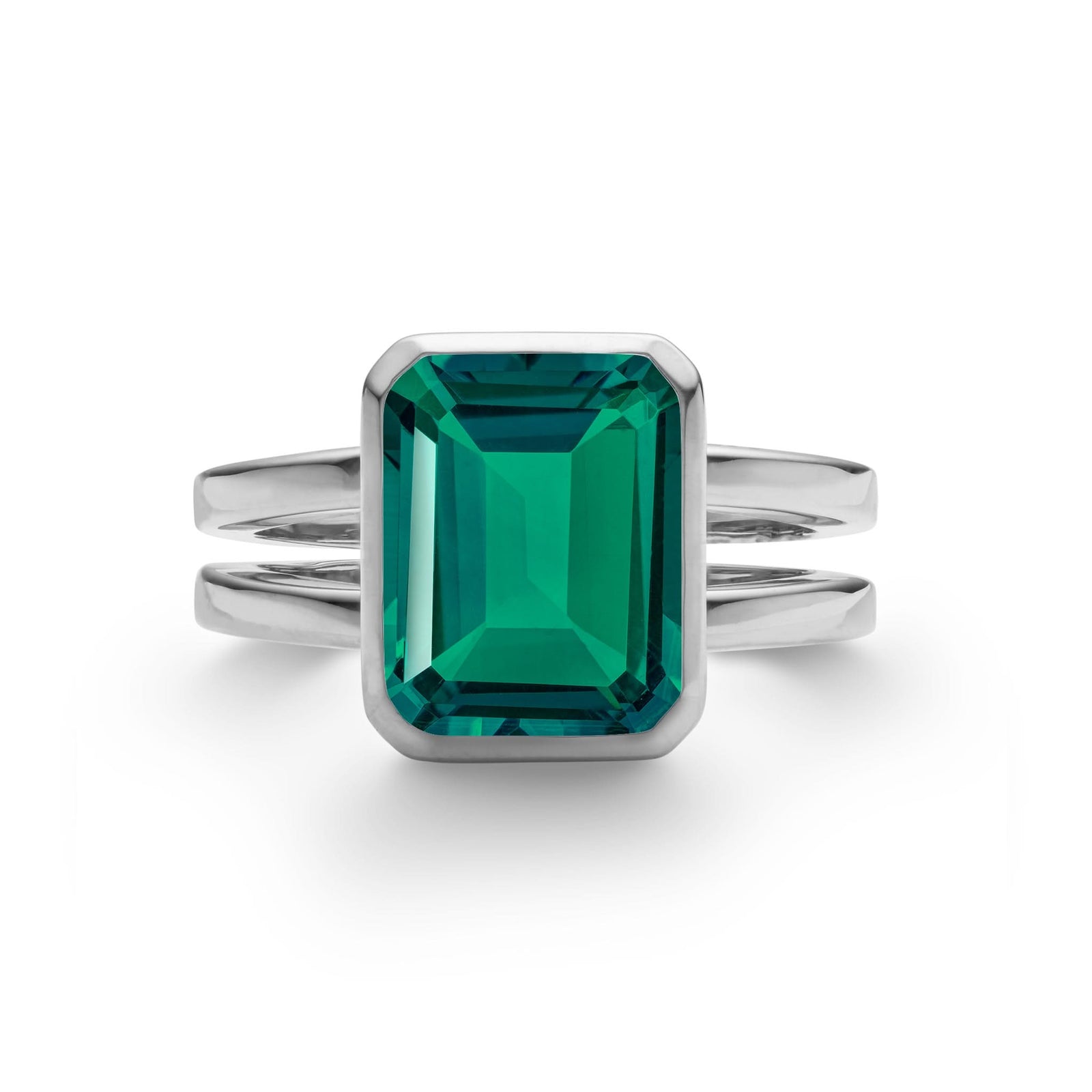 Warren ring in 14k white gold featuring one 10 x 8 mm emerald cut bezel set emerald - front view