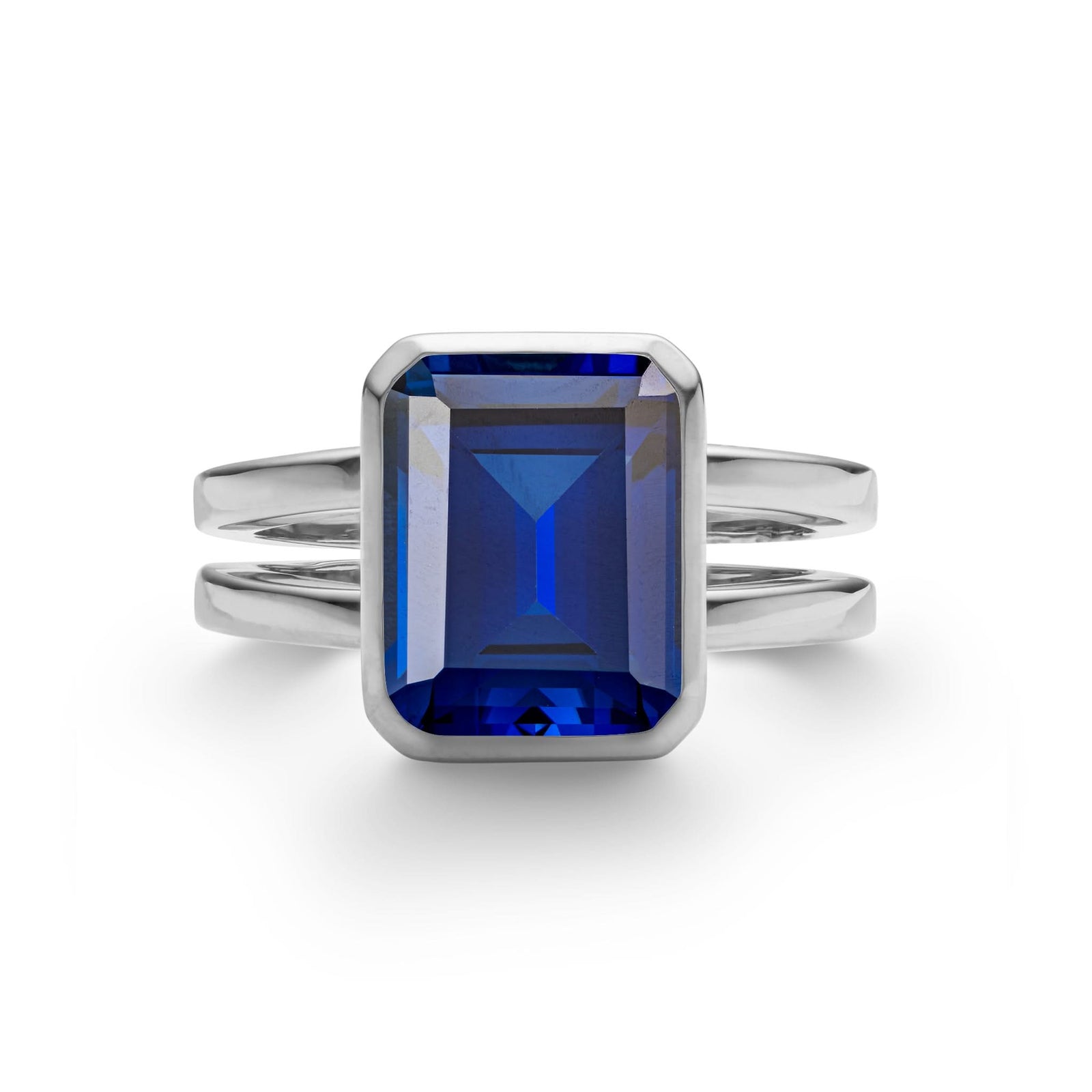 Warren ring in 14k white gold featuring one 10 x 8 mm emerald cut bezel set sapphire - front view