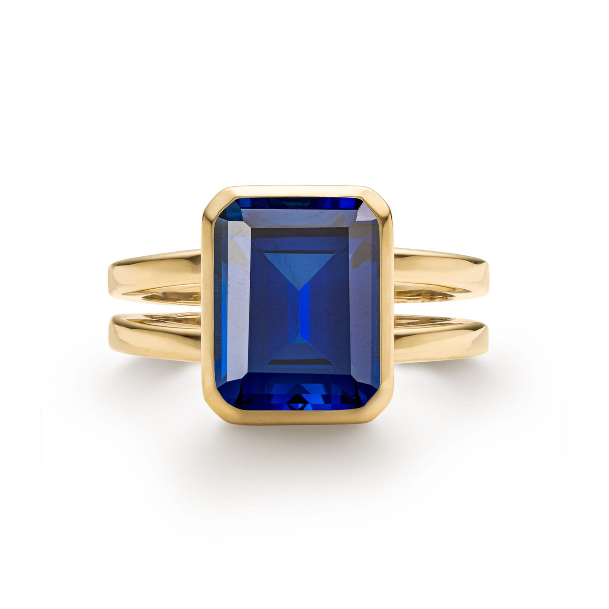 Warren ring in 14k yellow gold featuring one 10 x 8 mm emerald cut bezel set sapphire - front view