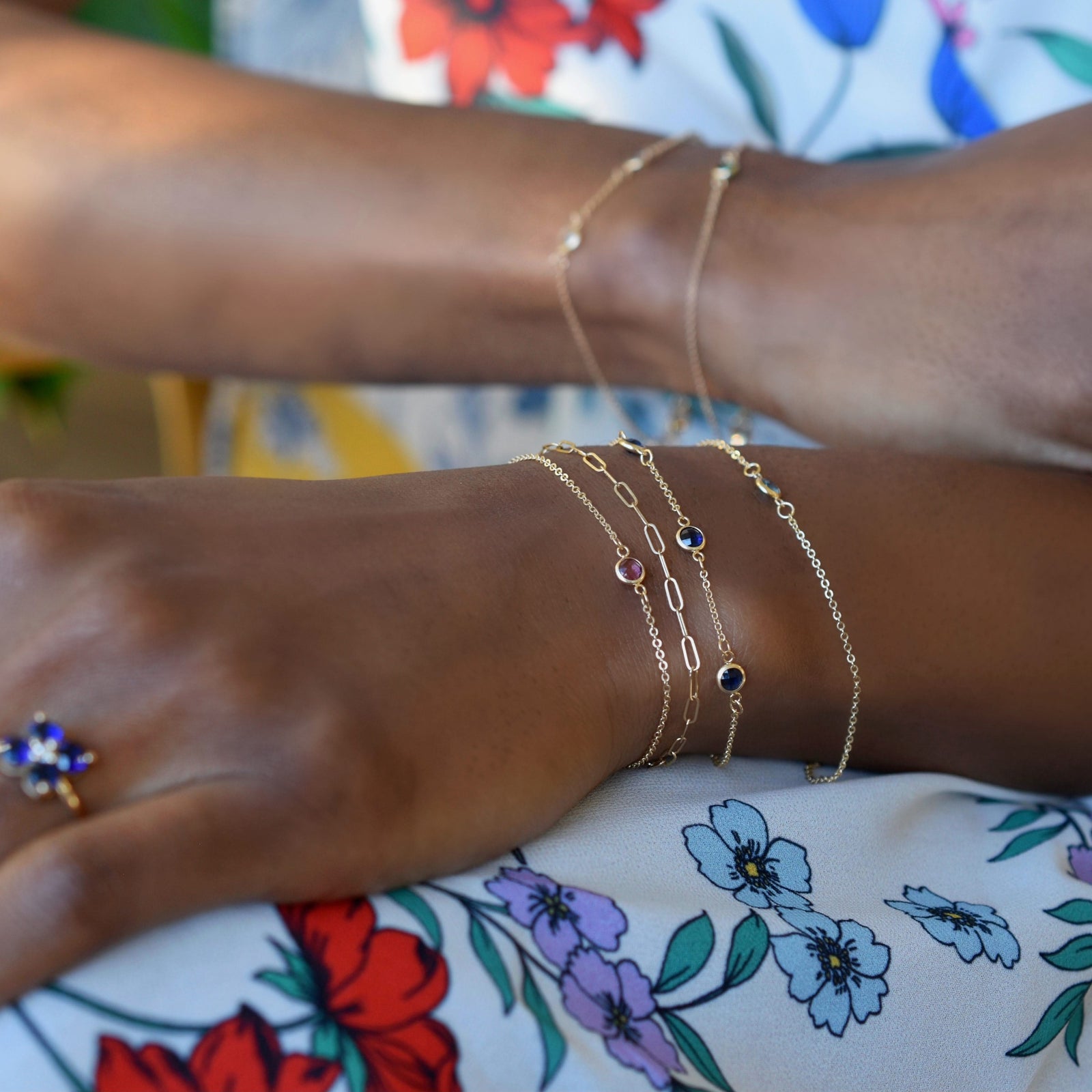 Woman wearing multiple bracelets including a Bayberry bracelet featuring three 4 mm briolette sapphires bezel set in 14k gold