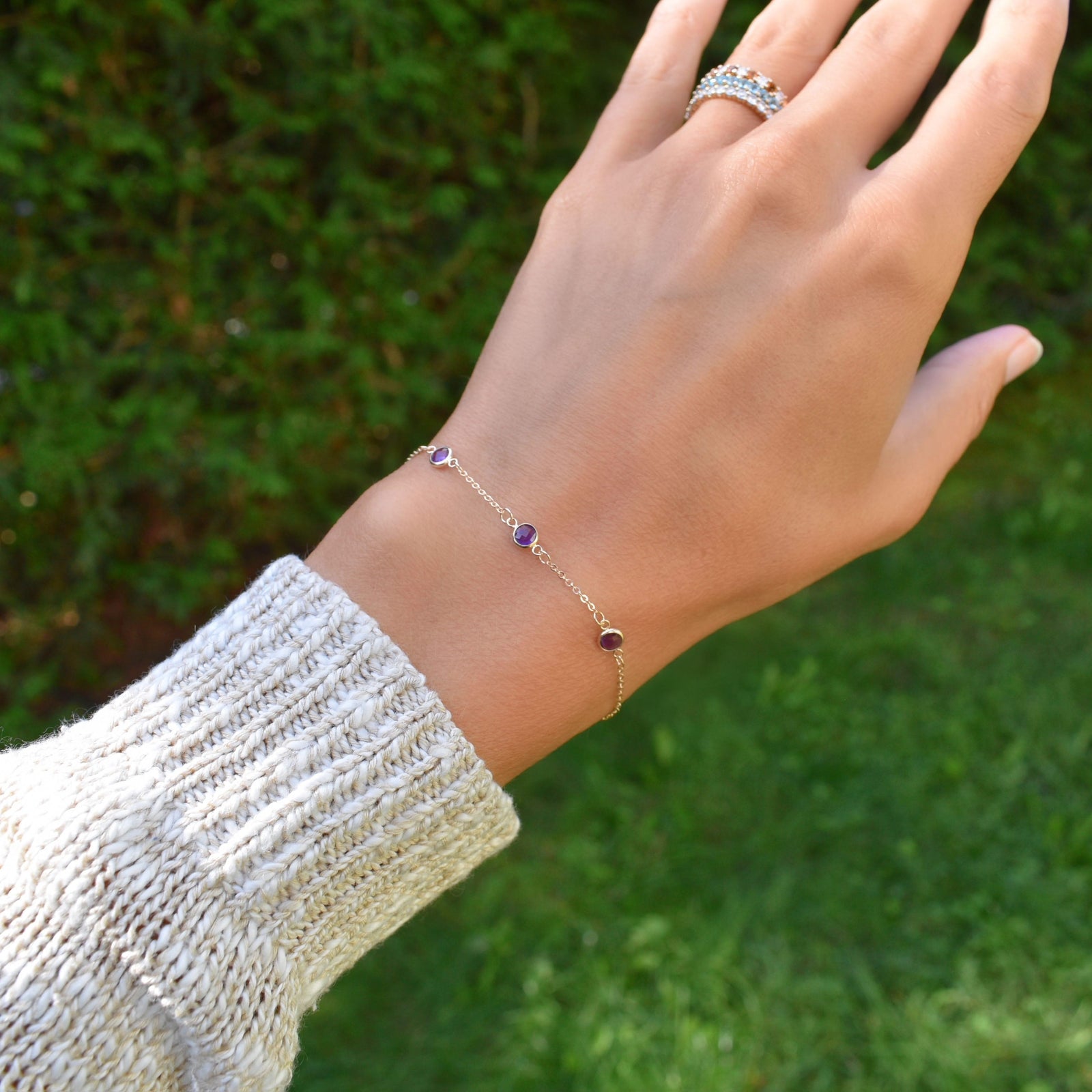 Woman wearing a Bayberry 1.17 mm cable chain bracelet featuring three 4 mm briolette cut amethysts bezel set in 14k gold