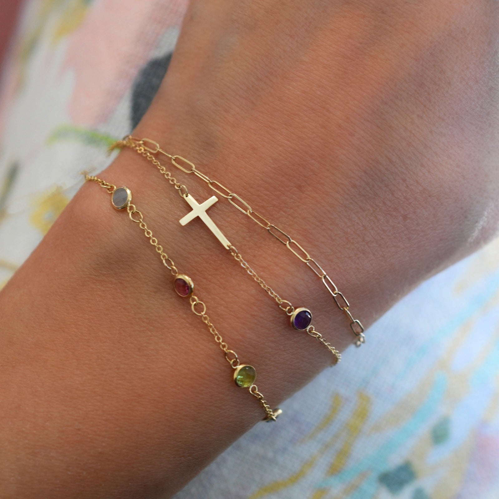Woman wearing three bracelets including a 14k yellow gold Classic necklace featuring one birthstone and a 1/2" cutout cross