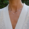 Woman wearing a Grand 14k gold 1.17 mm cable chain necklace featuring six 6 mm briolette cut bezel set gemstones