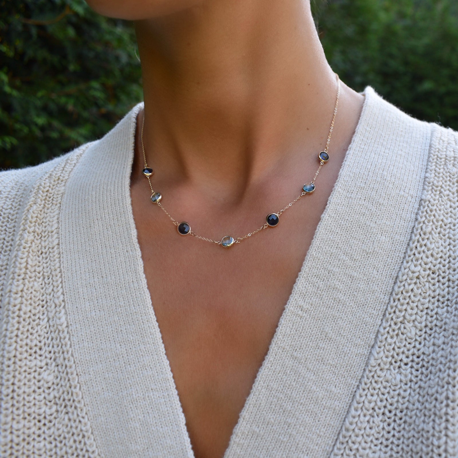 Woman with a Grand 14k yellow gold 1.17 mm cable chain necklace featuring seven 6 mm briolette cut bezel set gemstones