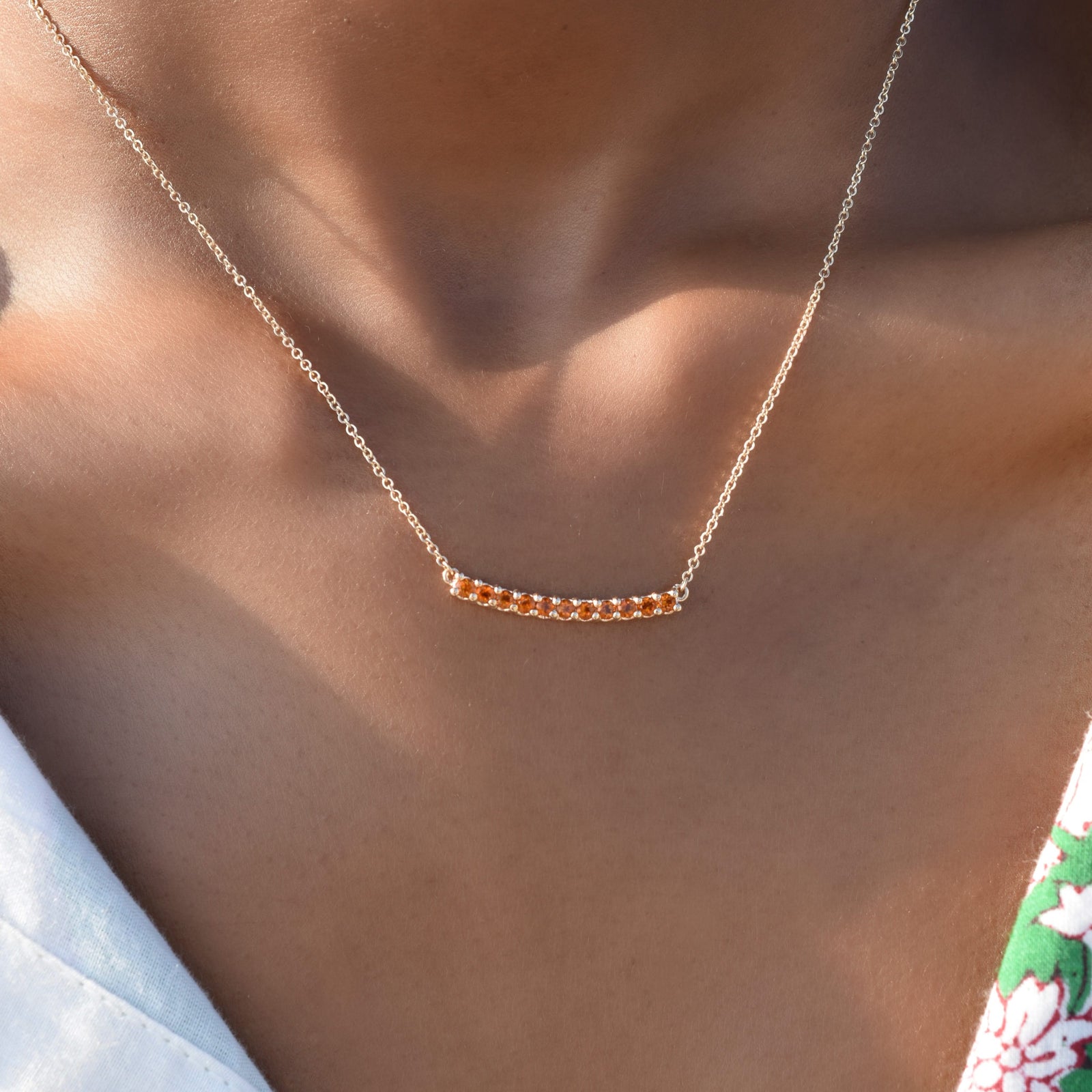 Woman wearing a Rosecliff bar necklace with eleven 2 mm faceted round cut citrines prong set in solid 14k yellow gold