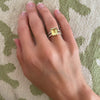 Woman's hand wearing a Warren ring in 14k gold with accent diamonds featuring one 10 x 8 mm emerald cut lemon verbena quartz