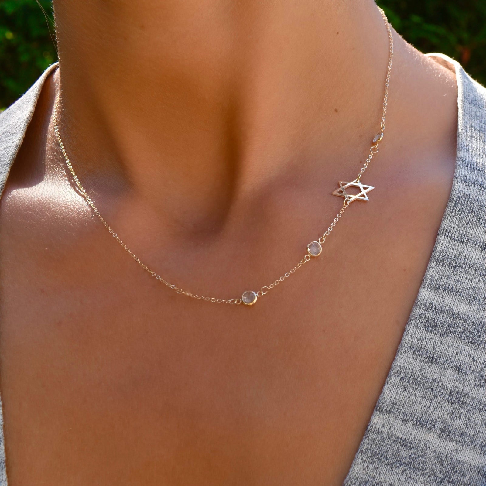 Woman with a 14k yellow gold Classic necklace featuring three birthstones and a 1/2" cutout Star of David
