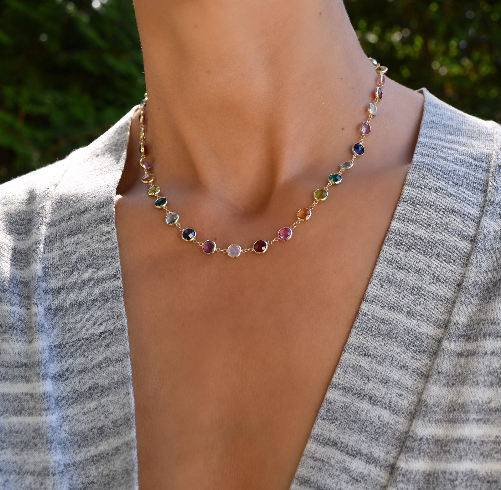 Woman with a Newport Grand 14k yellow gold necklace featuring 6 mm rainbow hued briolette cut bezel set gemstones