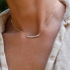 Woman with a Rosecliff bar necklace with eleven alternating 2 mm faceted round cut gemstones prong set in solid 14k gold