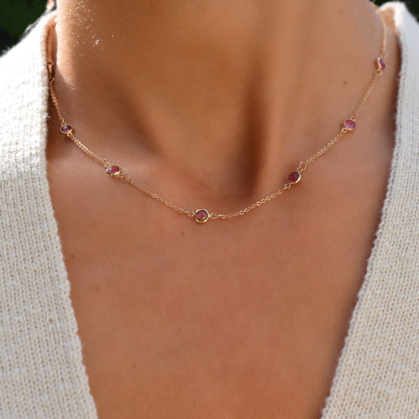 Woman wearing a Bayberry 11 Birthstone necklace featuring 4 mm briolette pink tourmalines bezel set in 14k yellow gold