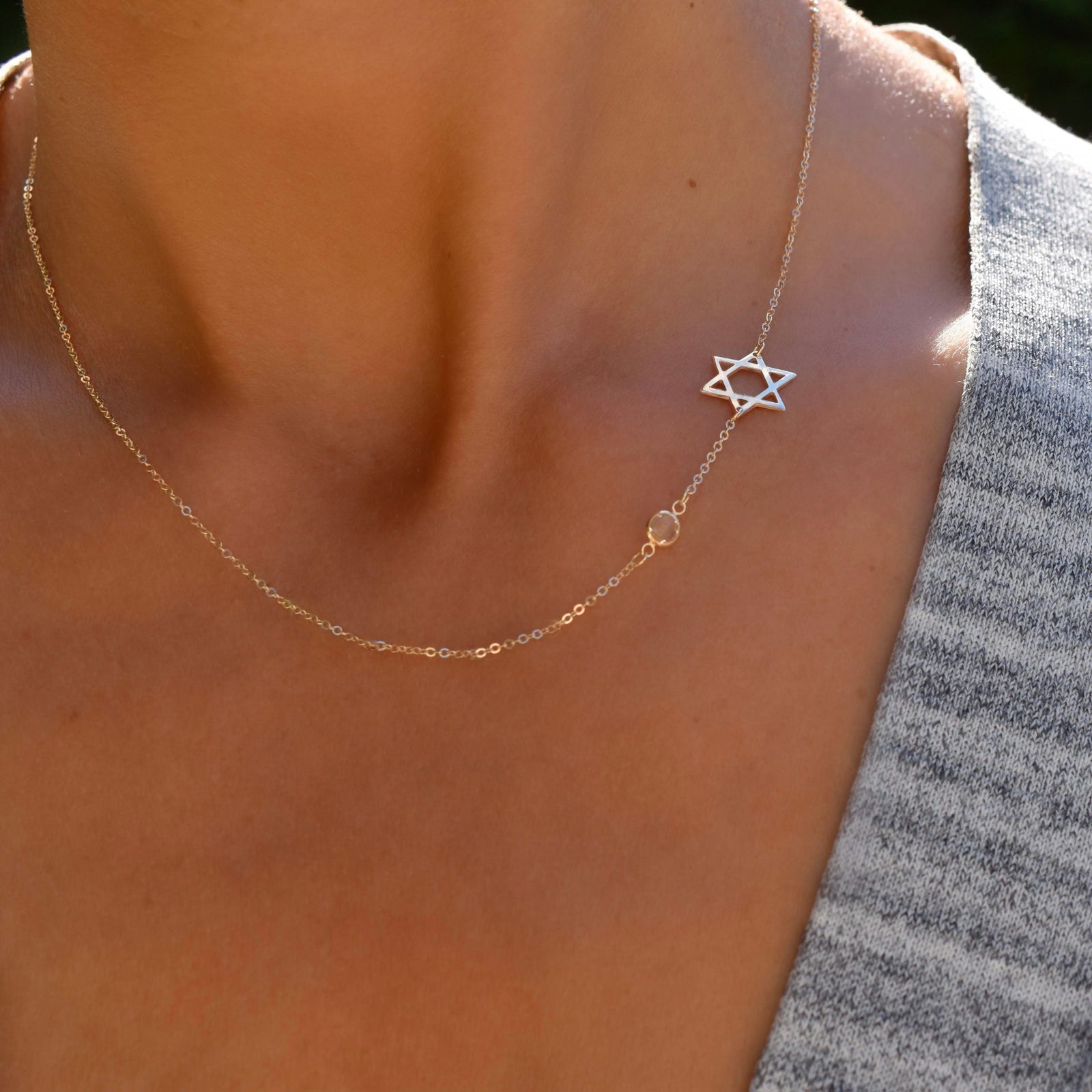 Woman wearing a 14k yellow gold Classic necklace featuring one birthstone and a 1/2" cutout Star of David