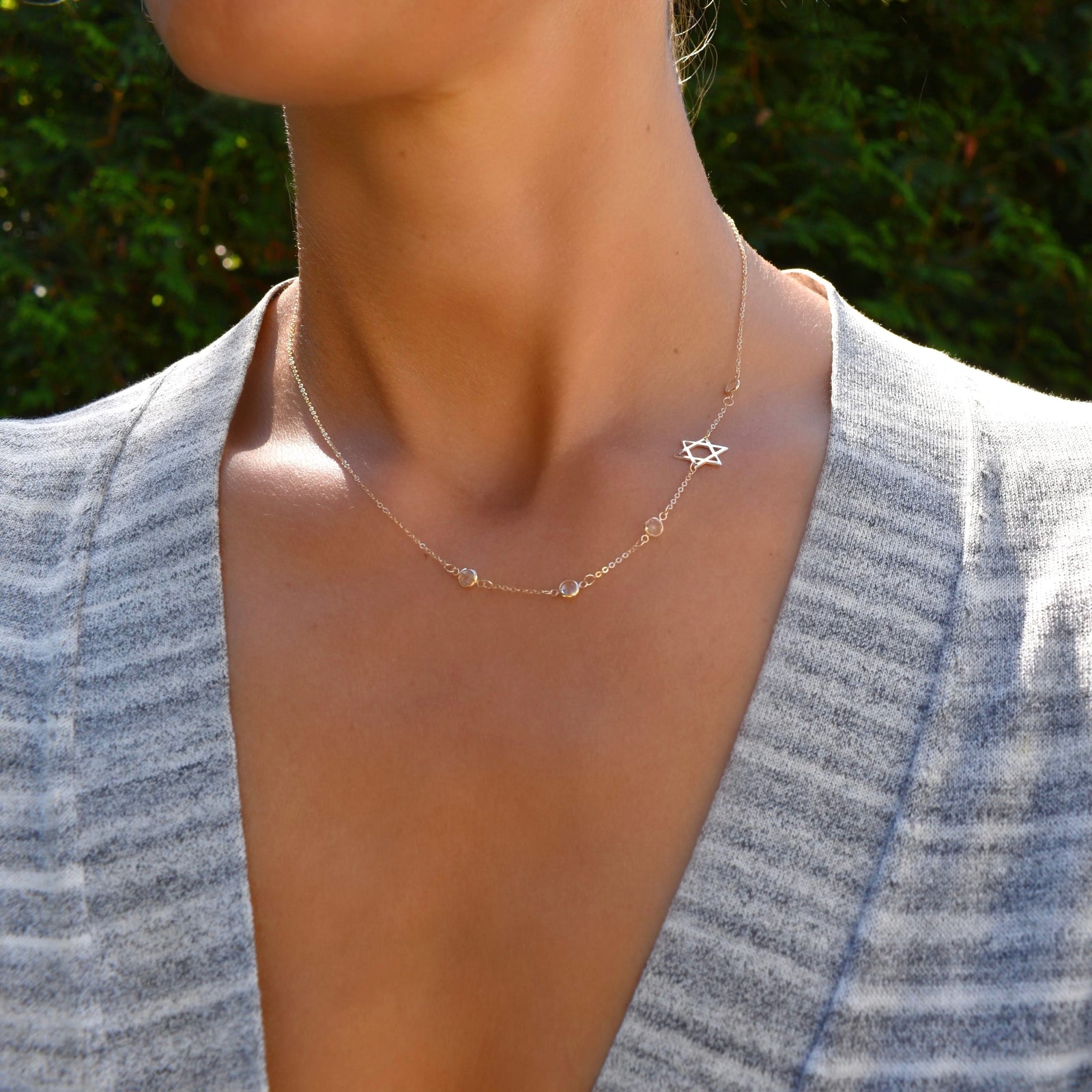 Woman wearing a 14k yellow gold Classic necklace featuring four birthstones and a 1/2" cutout Star of David