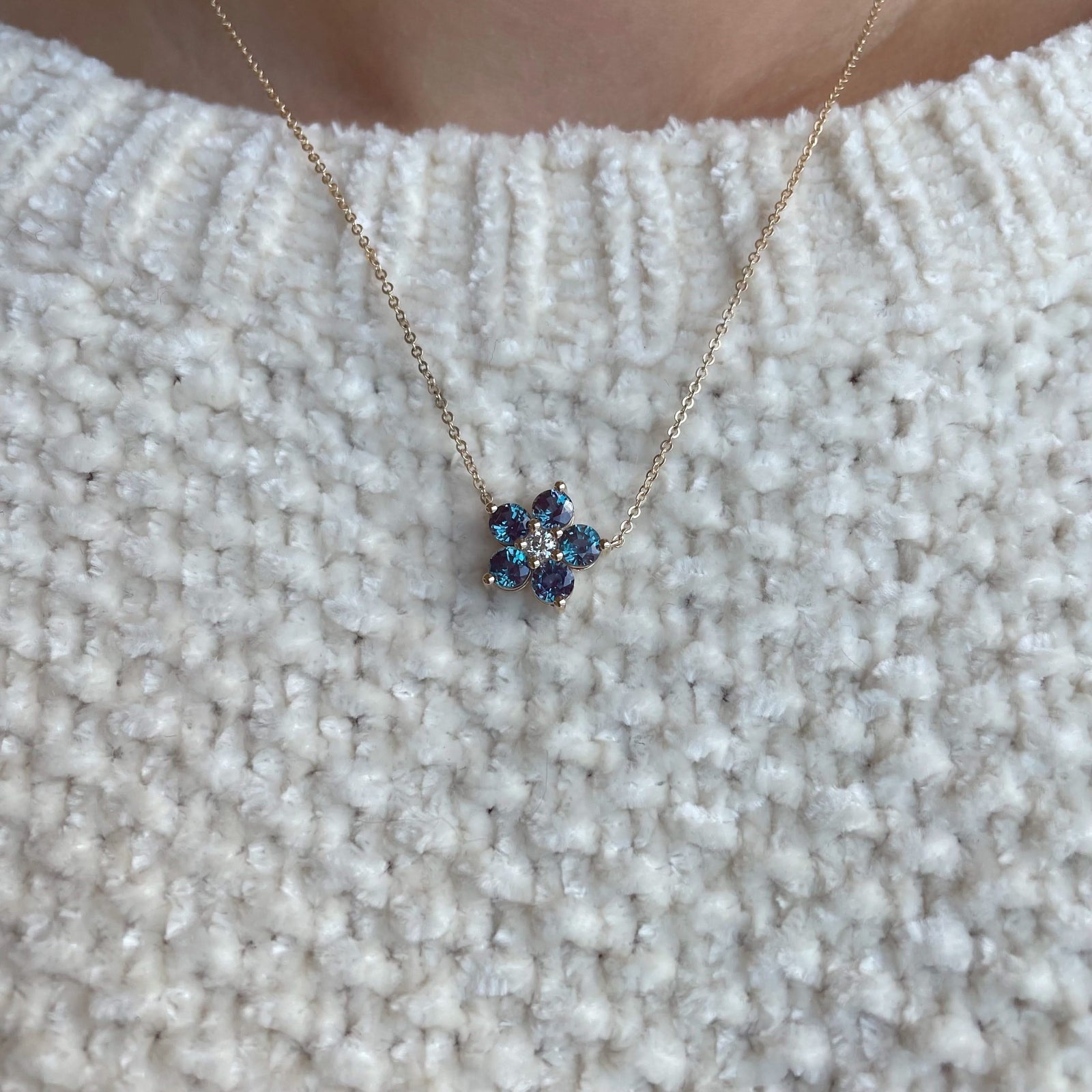 Woman with a Greenwich cable chain necklace featuring five 4 mm alexandrites and one 2.1 mm diamond bezel set in 14k gold