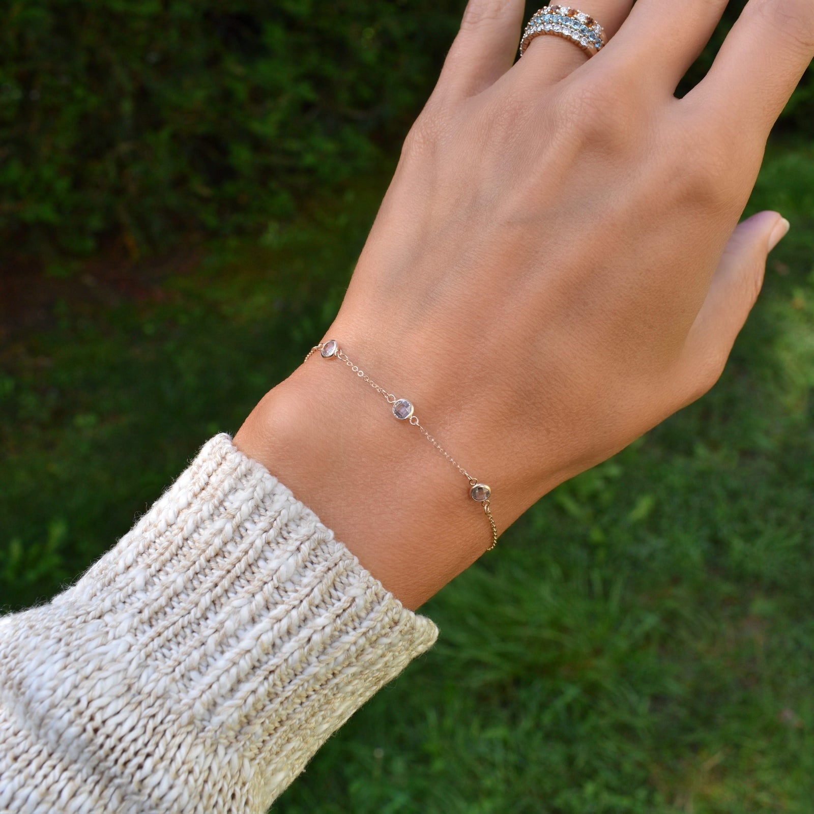 Woman wearing a Bayberry cable chain birthstone bracelet featuring three 4 mm briolette aquamarines bezel set in 14k gold