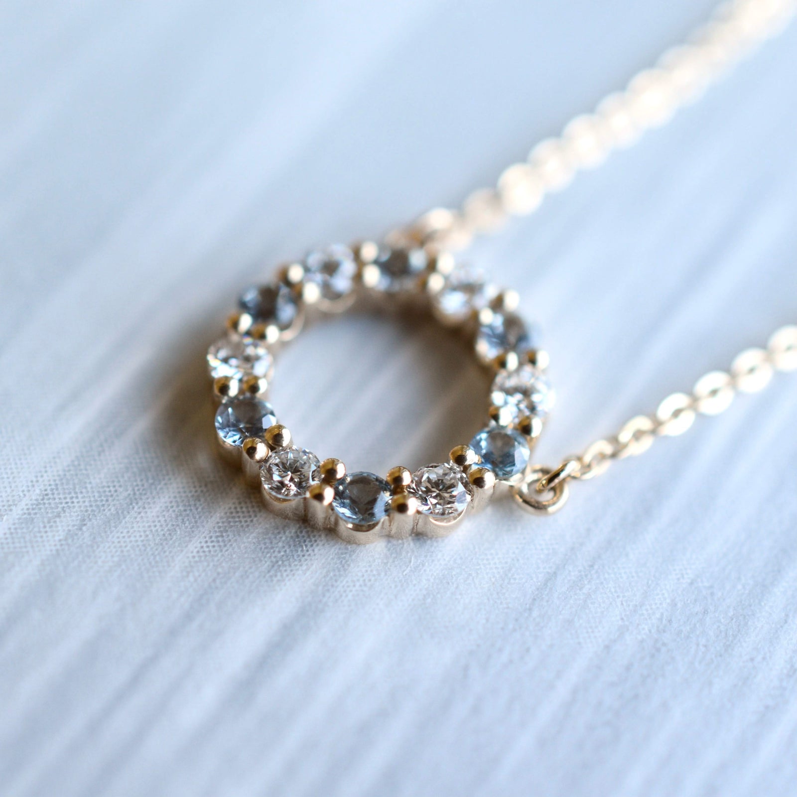 Rosecliff small open circle necklace with twelve alternating 2 mm round cut aquamarines & diamonds prong set in 14k gold