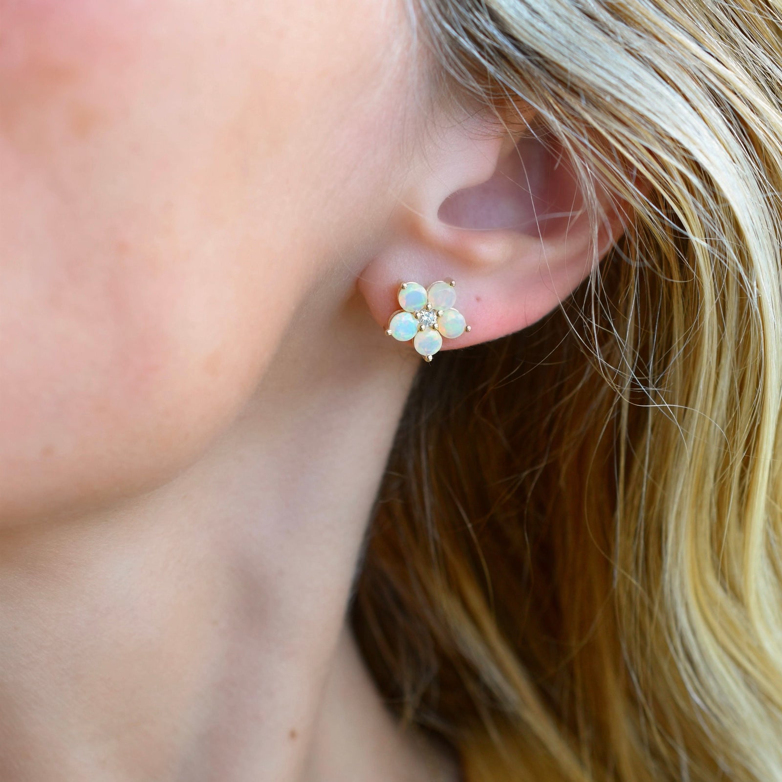 Woman wearing a 14k yellow gold Greenwich 5 Birthstone earring featuring five 4 mm opals and one 2.1 mm diamond