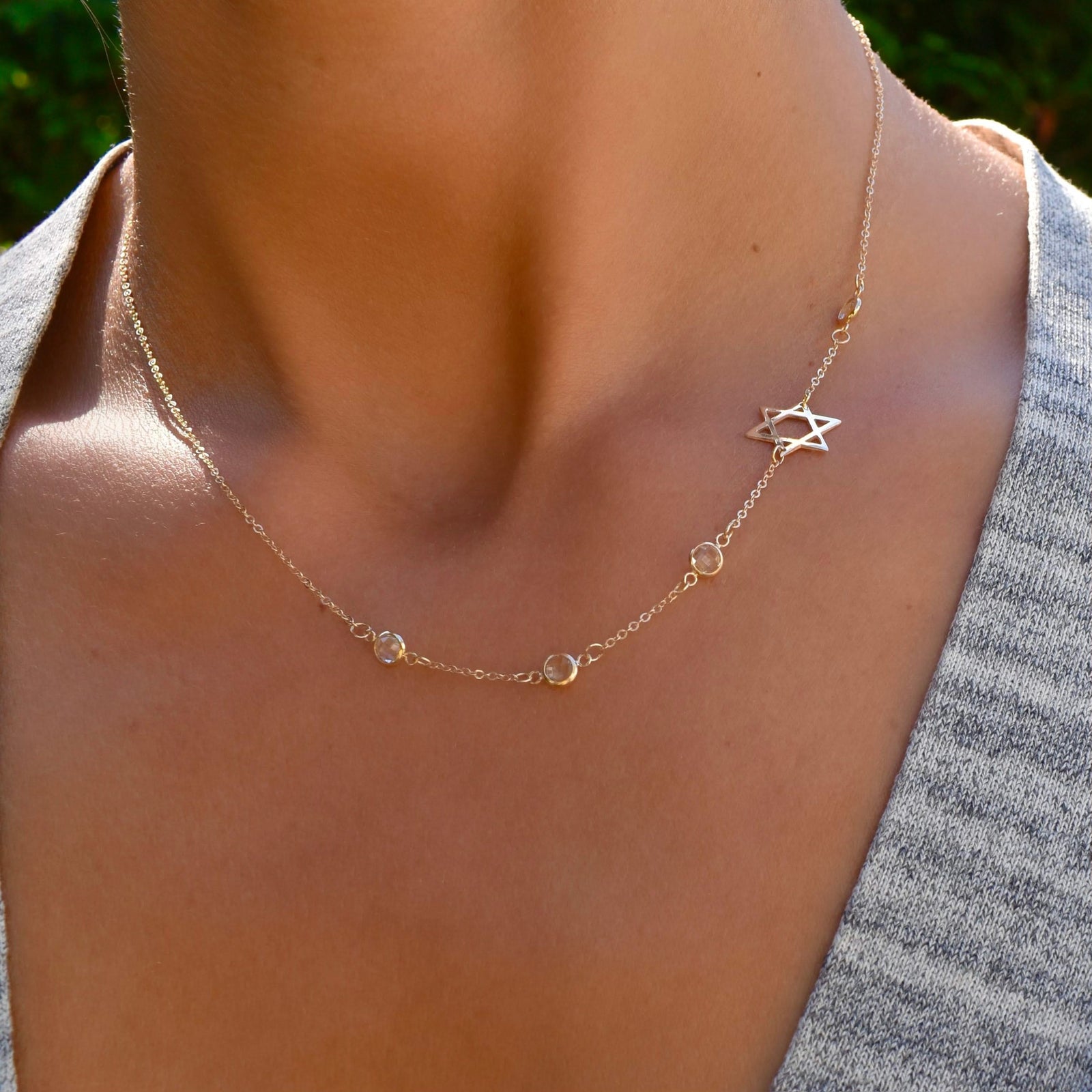 Woman with a 14k yellow gold Classic necklace featuring four birthstones and a 1/2" cutout Star of David