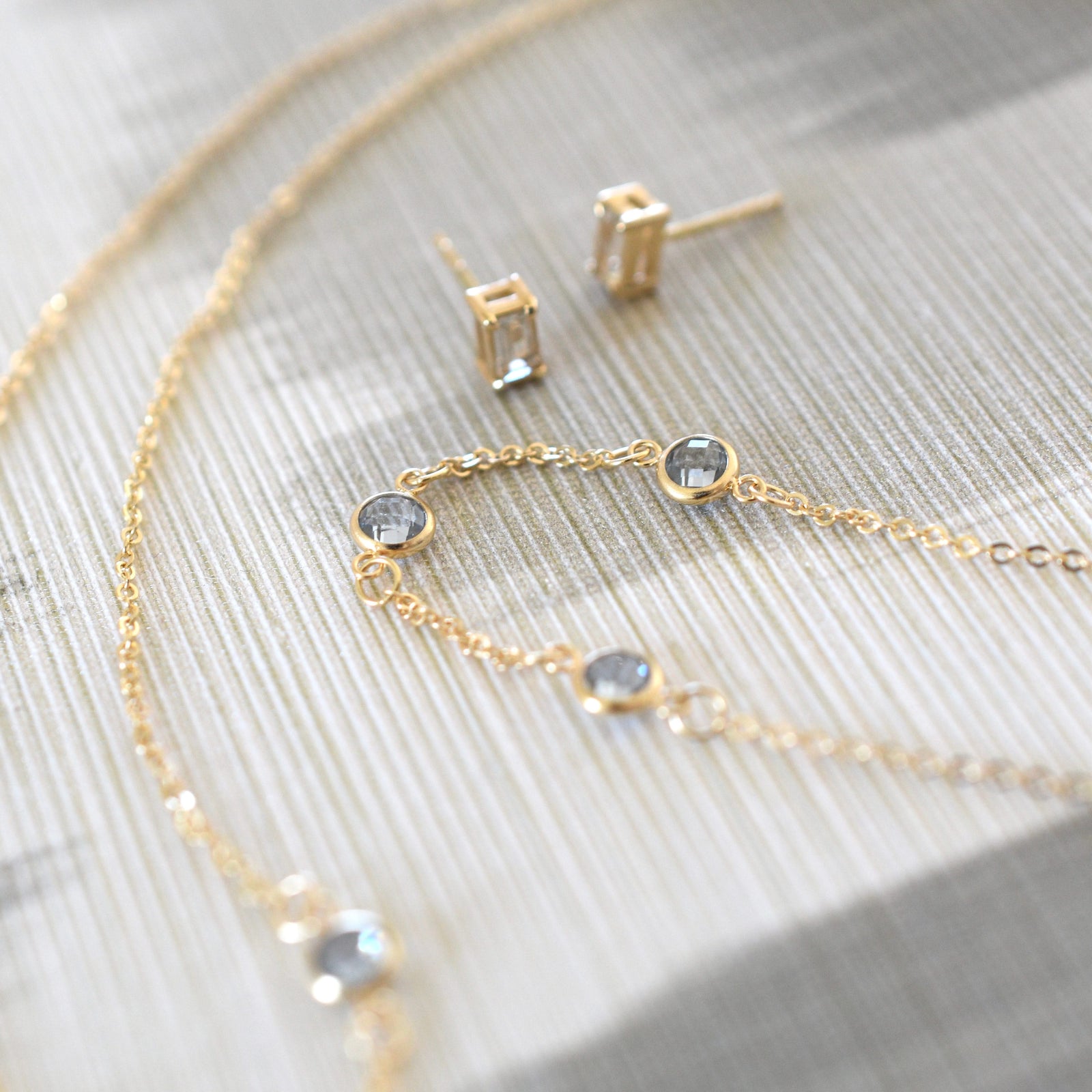 Jewelry including a Bayberry cable chain birthstone bracelet featuring three 4 mm briolette aquamarines bezel set in 14k gold