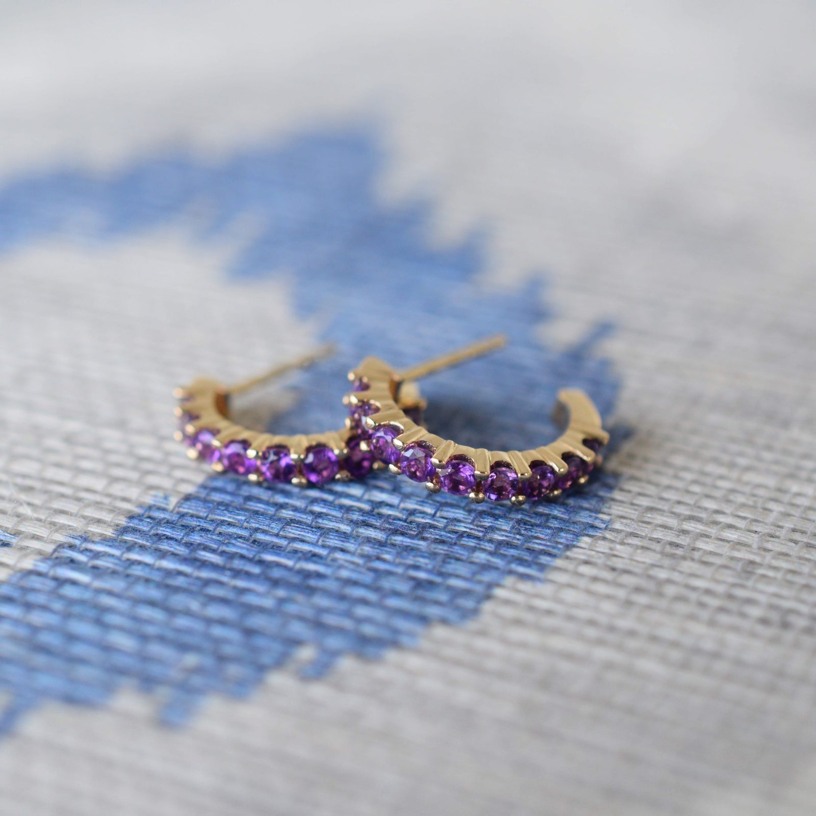 Rosecliff huggie earrings in 14k yellow gold featuring nine 2mm faceted round cut prong set amethysts