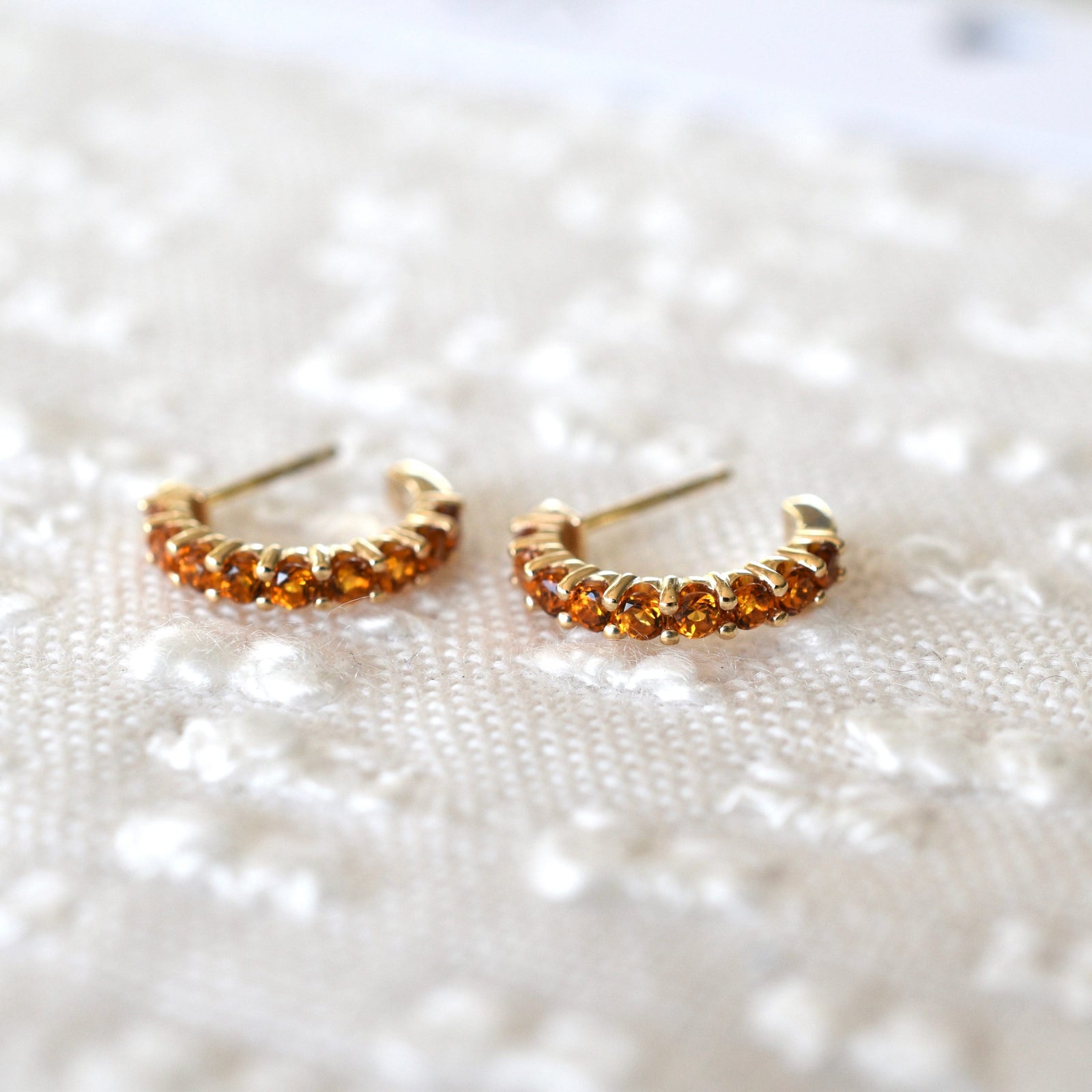 A pair of Rosecliff huggie earrings in 14k yellow gold featuring nine 2mm faceted round cut prong set citrines