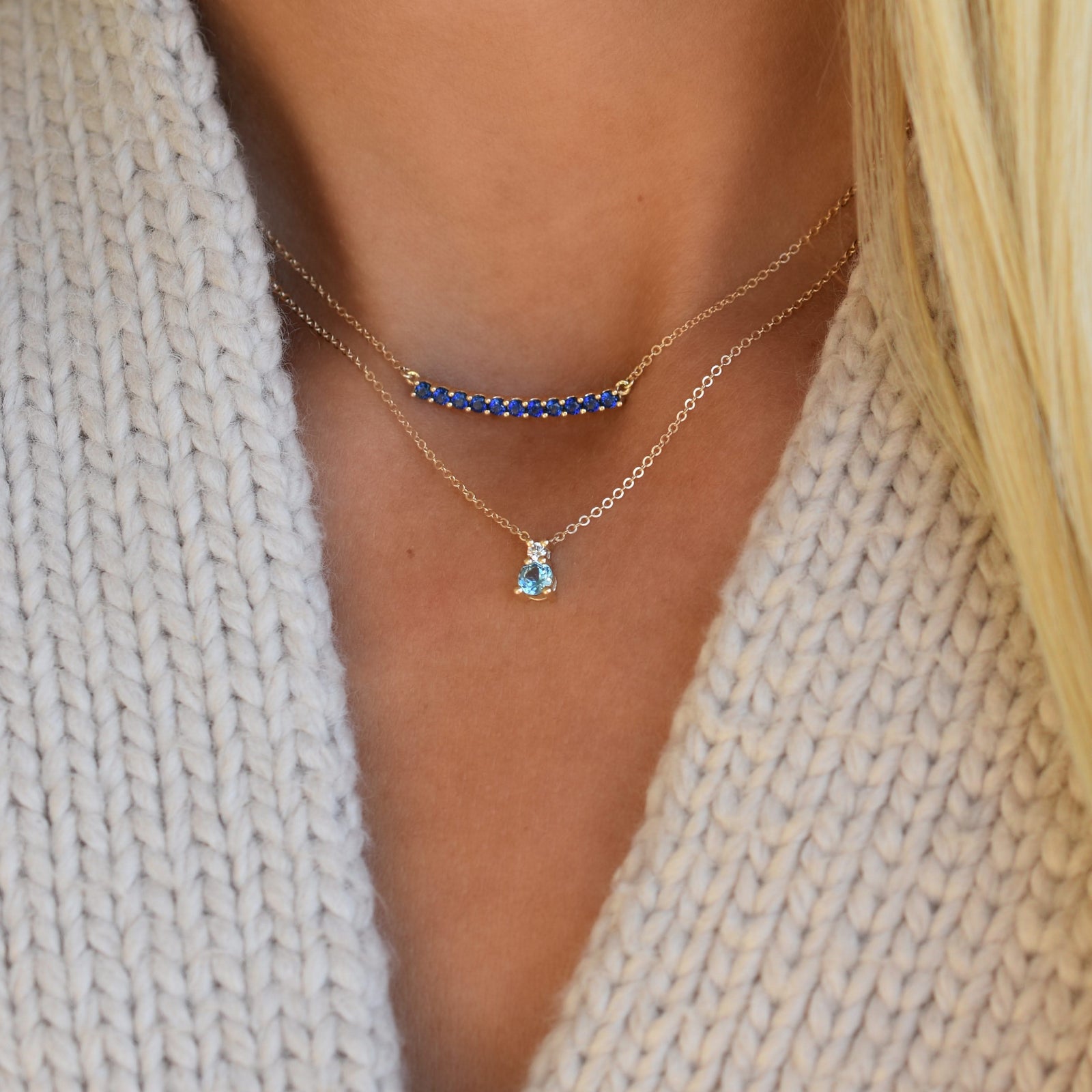 Woman wearing two gold necklaces including a Greenwich necklace featuring one 4 mm Nantucket blue topaz & one 2.1 mm diamond