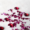 Rubies of various cuts scattered on a white background
