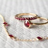 Rosecliff Ruby Stackable ring resting on a Grand Ruby ring with a Bayberry 3 Ruby bracelet in the foreground.