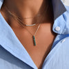 Woman wearing a layered Adelaide Mini necklace, a Rosecliff Diamond Bar necklace, and a Providence 6 Emerald pendant.